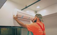 An HVAC tech installs a ductless unit in the ceiling of a Cornish Pasty restaurant.