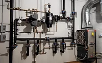 A geothermal mechanical room displays a selection of geothermal technology for contractors to learn, understand, and convey the benefits of to their customers.