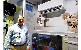 Victor Flynn stands next to the ClimaPure XE Series ductless heat pump system.