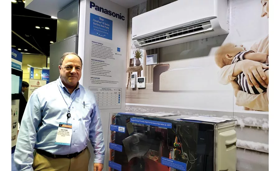 Victor Flynn stands next to the ClimaPure XE Series ductless heat pump system.