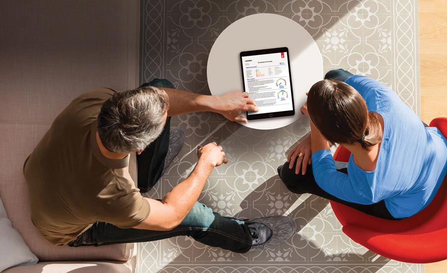 An HVAC contractor meets with a potential customer to review the features of a smart thermostat.