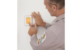 A technician installs a smart thermostat.