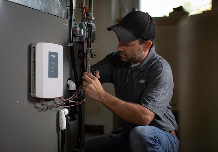 A technician works on the controls for a home’s HVAC.