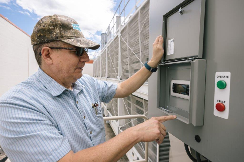 Conrad Campos, outside HVAC salesman at rep firm Midgley-Huber, Inc. checks setpoint temperature on the EVAPCO fluid cooler.