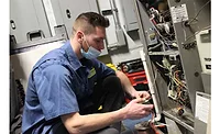Jake from Charter Home Comfort works on the installation at the Vets Returning Home facility.