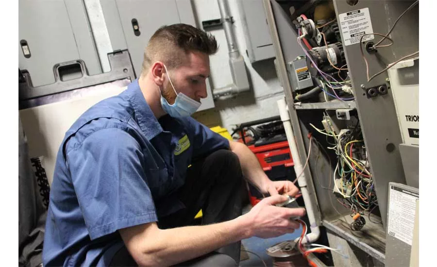 Jake from Charter Home Comfort works on the installation at the Vets Returning Home facility.