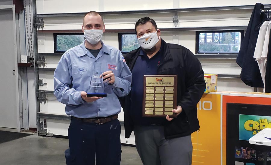 Swift Services installer/tech Josiah Kidman (left) receives the Employee of the Year award from general manager Shane Bedgood (right).