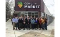 Representatives from Emerson, Chemours, Hussmann, and the Gem City Market board gather in front of the soon-to-open Gem City Market.