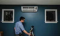 Residential-Ductless-Unit-01.jpg A technician installs a ductless unit in a consumer’s home.