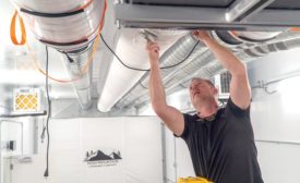 A technician installs a fabric duct at High Mountain LLC in Vassar, Michigan.