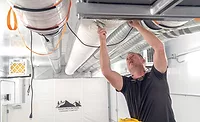 A technician installs a fabric duct at High Mountain LLC in Vassar, Michigan.