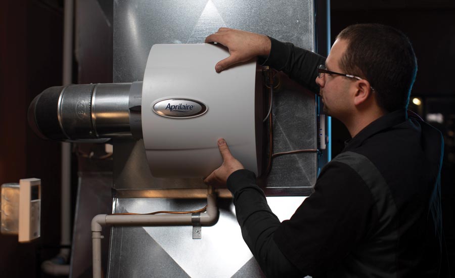 A technician installs the Aprilaire 600 whole-home evaporative humidifier.