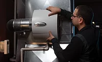 A technician installs the Aprilaire 600 whole-home evaporative humidifier.