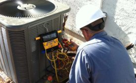 HVAC technician servicing air conditioner.