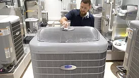 worker with Carrier Infinity heat pump