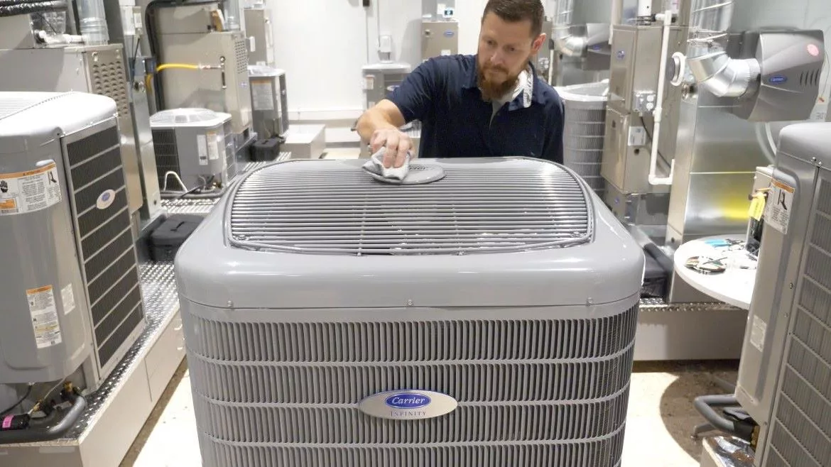 worker with Carrier Infinity heat pump