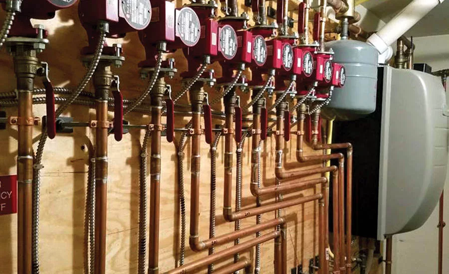 A wall-mounted boiler and piping system installed at a 32-unit apartment complex