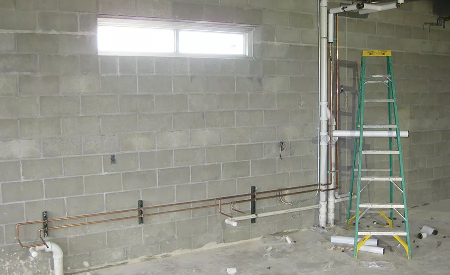 Plumbing piping rough-in for science lab casework with vents combined above the flood rim level