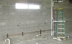 Plumbing piping rough-in for science lab casework with vents combined above the flood rim level