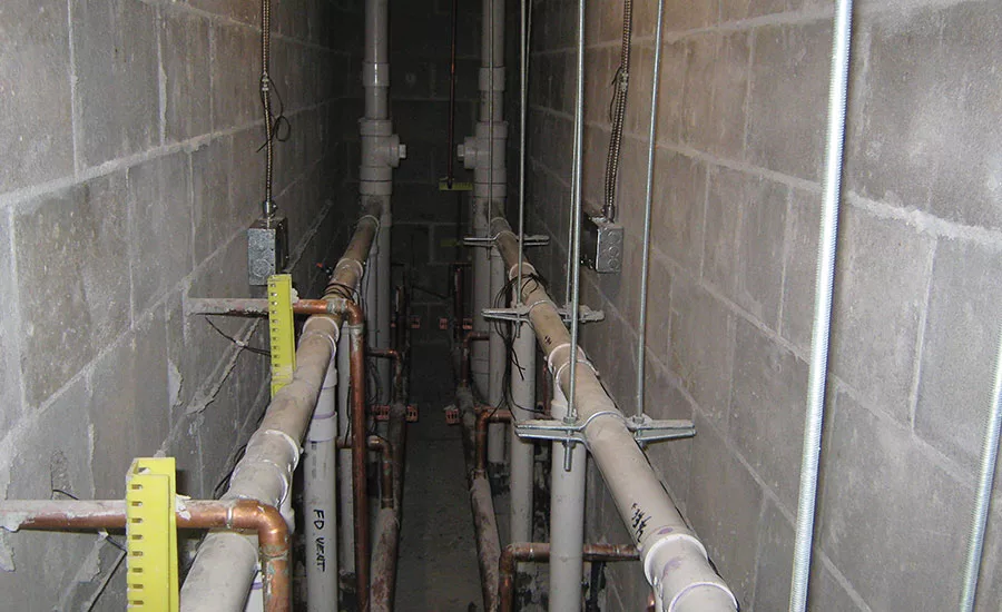 A plumbing fixture group back-to-back chase with PVC waste and vent piping and copper water piping