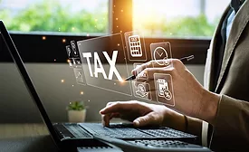 tax graphic over a person working on a laptop